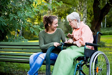 A young woman and older woman enjoying talking together outside.