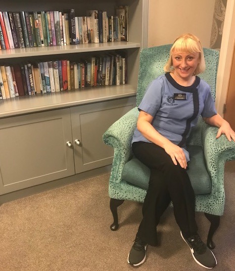 Image of Susan sitting in the care home’s library.